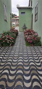 a brick walkway in front of a building with flowers at Chalé Vila do Vento in Lavras Novas