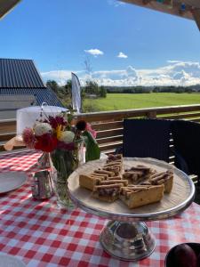 a table with a plate of food on a table with flowers at Rosenli Gård in Tønsberg
