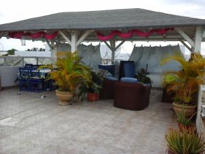 a pavilion with chairs and potted plants on a patio at Nely y Pietro share apartment in Punta Cana