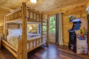 a bedroom with a bunk bed and a video game at Ridge Hollow Retreat - Hot Tub, Fire Pit, Dogs in Gatlinburg