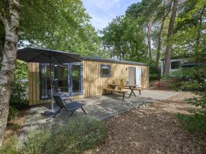 a small cabin with an umbrella and a patio at Steltloper in Nunspeet