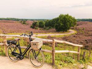 a bike parked next to a fence on a dirt road at Steltloper in Nunspeet
