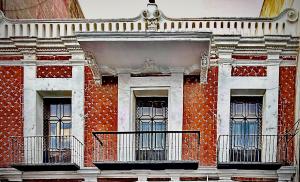 a red and white building with windows and a balcony at Hotel de Talavera in Puebla