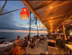 a group of people sitting at a restaurant overlooking the ocean at NO name bangalow in Ko Lanta Yai