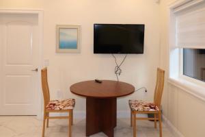 a dining room with a table and a flat screen tv at SixPine - One bedroom suite in Vancouver