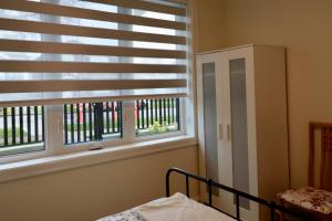 a bedroom with a bed and a window with blinds at SixPine - One bedroom suite in Vancouver