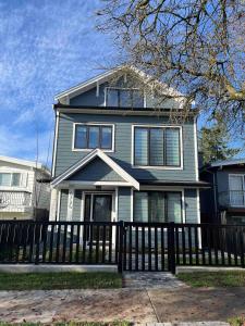 a house with a fence in front of it at SixPine - One bedroom suite in Vancouver