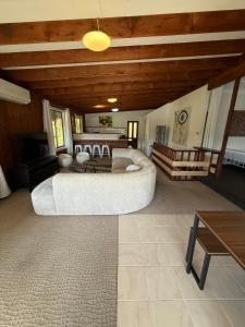a large living room with a large bed and a table at Terrigal Cottage in Terrigal