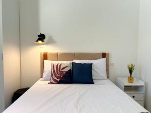 a bed with white sheets and blue pillows at AP Smart Samaritan Fast Internet Office in Campinas