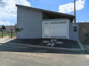 a white garage with a flower painted on it at Recanto do sol in Brotas