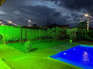 a backyard with a swimming pool and green grass at Recanto do sol in Brotas