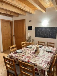 a dining room with a table and chairs and a chalkboard at BORMIO Alpine Suite in Valdidentro +25 photos