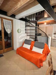 a bedroom with a bed with an orange blanket at BORMIO Alpine Suite in Valdidentro