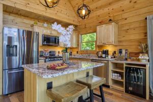 a kitchen with a center island in a wooden kitchen at Ridge Hollow Retreat - Hot Tub, Fire Pit, Dogs in Gatlinburg