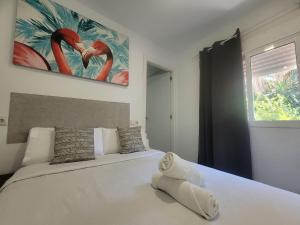 a bedroom with a white bed with a painting on the wall at AYZ Silvela - Auto check-in property in Málaga