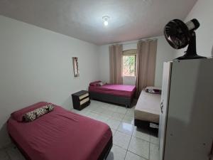 a bedroom with two beds and a refrigerator at Hostel Repou-Z in Goiânia +11 photos
