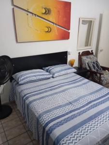 a bed in a bedroom with a painting on the wall at Pousada Hostel Brasil Gru in Guarulhos