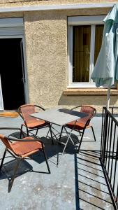 two chairs and a table and an umbrella on a patio at Casa Sole in Saint-Chamond