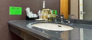 a bathroom counter with a sink and a mirror at ホテルスター in Iwaki