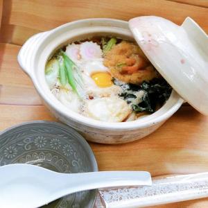 a bowl of soup with an egg on a table at ホテルスター in Iwaki