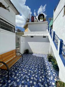 a bench on a balcony with blue and white tiles at Casa Bienestar in Guatemala