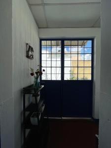 a room with a blue door and a shelf with flowers at Casa Bienestar in Guatemala