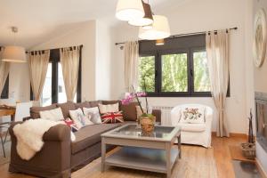 ein Wohnzimmer mit einem Sofa und einem Tisch in der Unterkunft Tarter Mountain Suites in El Tarter