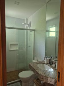 a bathroom with a sink and a toilet and a mirror at Paraíso em Imbassaí in Imbassai +24 photos