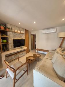 a living room with a couch and a fireplace at Paraíso em Imbassaí in Imbassai