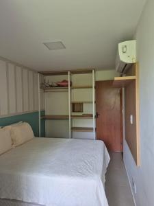 a bedroom with a bed and a room with shelves at Paraíso em Imbassaí in Imbassai