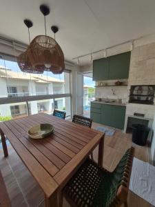 a kitchen and dining room with a wooden table and chairs at Paraíso em Imbassaí in Imbassai
