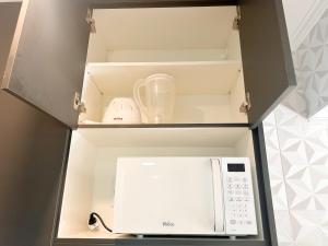 a microwave oven in a kitchen with a cupboard at AP Smart Center in Campinas +20 photos