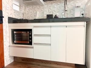 a kitchen with white cabinets and a microwave at AP Smart Center in Campinas