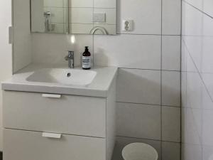 a white bathroom with a sink and a mirror at 6 person holiday home in Dyrvik in Dyrvik