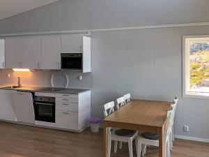 a kitchen and dining room with a table and chairs at 6 person holiday home in Dyrvik in Dyrvik +24 photos