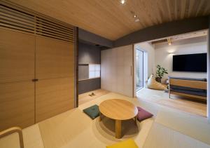 a living room with a table and a bed at Cortile in Mitoyo