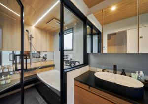a bathroom with a large sink and a tub and a mirror at Cortile in Mitoyo +4 photos