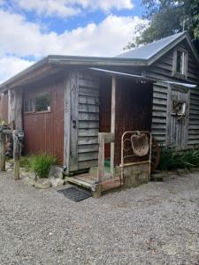 an old shed with a chair in front of it at Edens retreat in Upper Moutere
