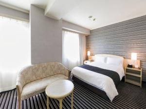 a hotel room with a bed and a chair at APA Hotel Fujichuo in Fuji +54 photos