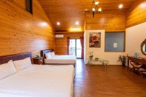 a bedroom with two beds in a room with wooden walls at Walk Cloud Bed and Breakfast in Meishan