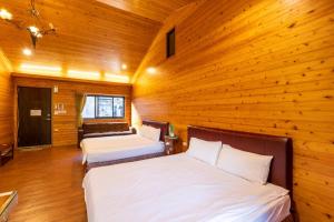 two beds in a room with wooden walls at Walk Cloud Bed and Breakfast in Meishan +16 photos