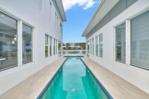 an indoor swimming pool in a house with windows at Deja View Trinity Beach in Trinity Beach