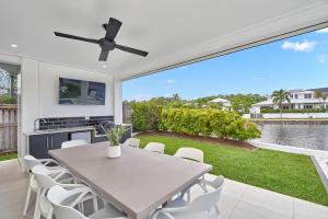 a dining room with a table and white chairs at Deja View Trinity Beach in Trinity Beach +22 photos