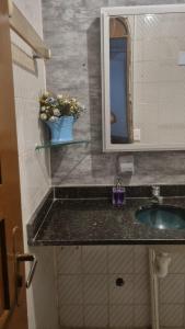 a bathroom counter with a sink and a mirror at Flat da Luz in Guarabira