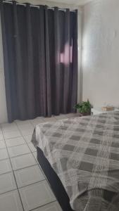 a bedroom with a bed and a black curtain at Flat da Luz in Guarabira