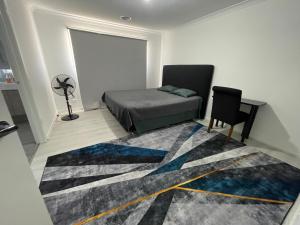 a bedroom with a bed and a desk and a rug at Ensuite room in Mount Duneed in Mount Duneed