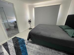a bedroom with a bed and a bathroom with a mirror at Ensuite room in Mount Duneed in Mount Duneed