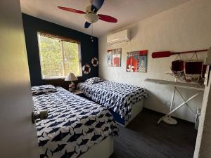 a bedroom with two beds and a ceiling fan at Marineros Vallarta in Puerto Vallarta