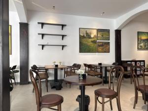 a restaurant with tables and chairs and paintings on the wall at Dresidence Hotel Ninh Binh in Ninh Binh +28 photos