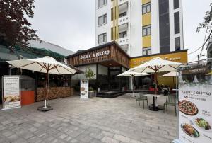 a courtyard with tables and umbrellas in front of buildings at Dresidence Hotel Ninh Binh in Ninh Binh